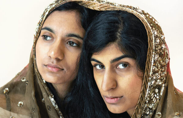 headshot of two people with a scarf covering their heads