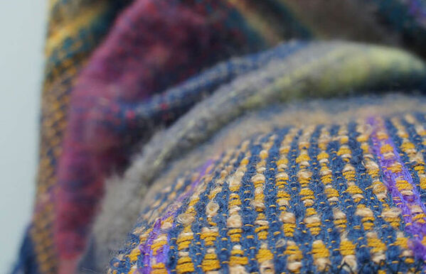 close up of purple, blue and yellow knitted blanket