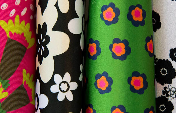 four floral, neon, black and white printed rolls of silk fabric