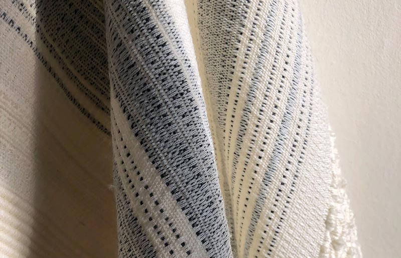 close up of cream and blue speckled knitted blanket