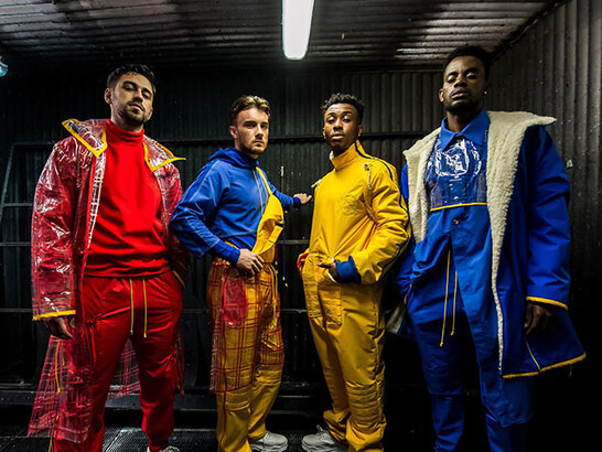 four males wearing red yellow, blue and transparent clothing 