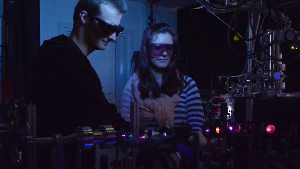 Students wearing goggles in dark lab