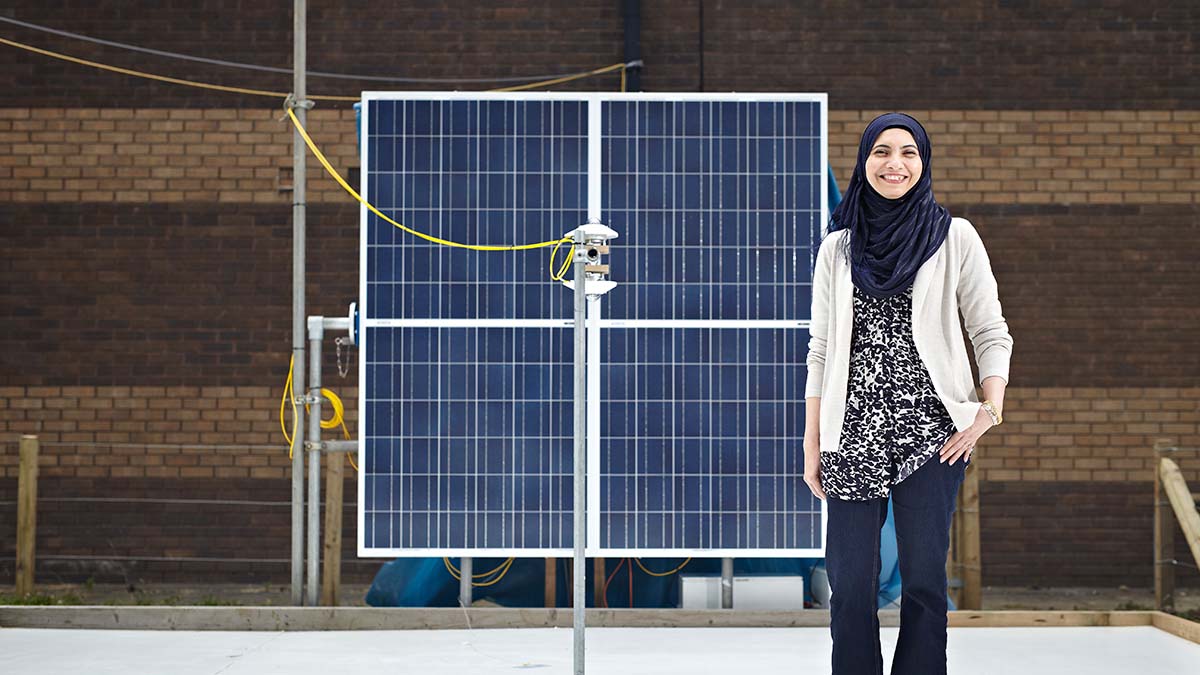Woman engineer standing in front of a solar panel