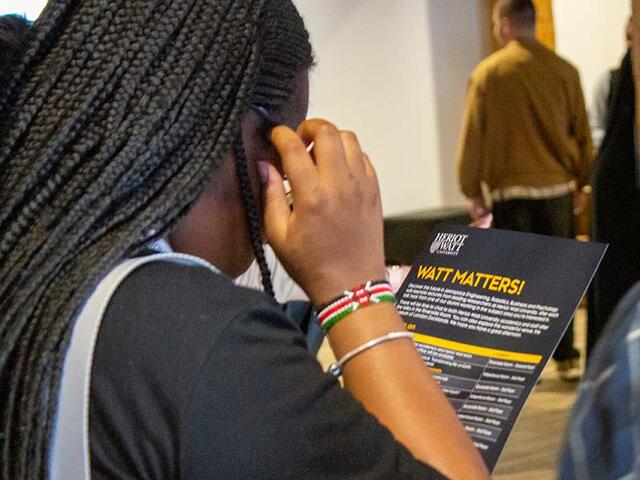 A young woman reading a Watt Matters leaflet